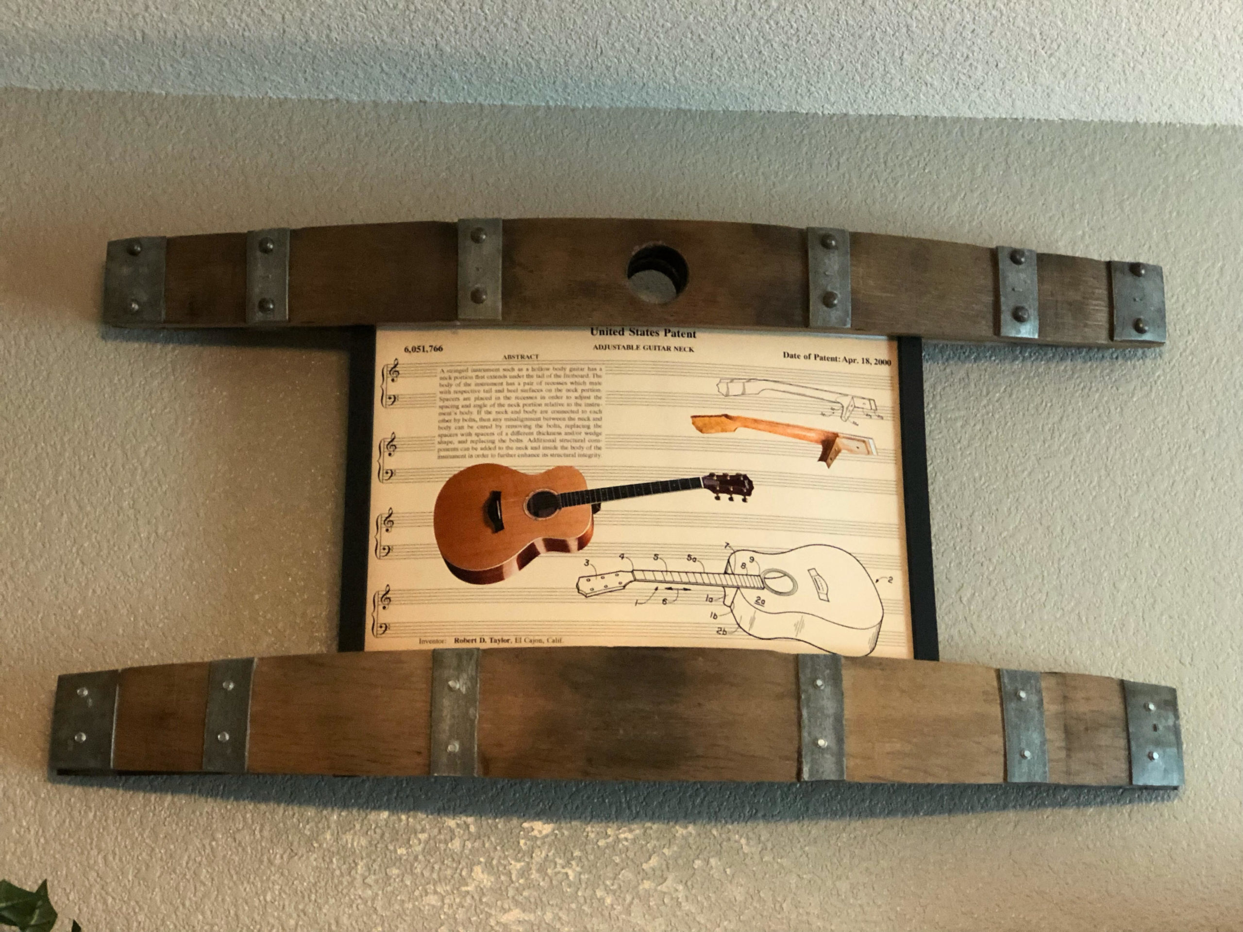 Guitar patent print framed between two wine barrel staves